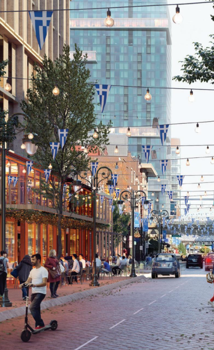Belebte Stadtstraße mit Cafés, Lichterketten, Fußgängern und E‑Scooter.
